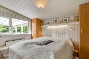 a bedroom with a white bed in a room with windows at C11663-Hemmet-Mosevaenget-9 in Hemmet