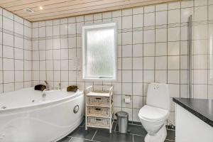 a bathroom with a tub and a toilet and a sink at C11663-Hemmet-Mosevaenget-9 in Hemmet +33 photos