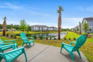 a group of blue chairs on a patio with a pond at RentPar4 in Little River