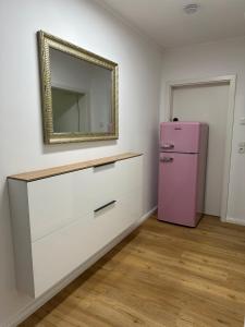 a pink refrigerator in a room with a mirror at Ferienwohnung MarLeo Landsberg am Lech in Landsberg am Lech