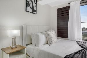 a white bedroom with a bed and a window at Luxury Private Apt at Disney Area in Orlando