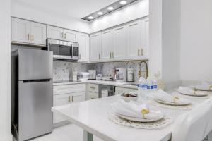 a white kitchen with white appliances and white cabinets at Luxury Private Apt at Disney Area in Orlando