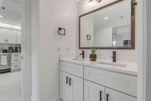 a white bathroom with two sinks and a mirror at Luxury Private Apt at Disney Area in Orlando