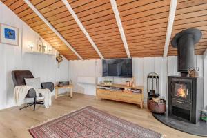 sala de estar con estufa de leña y TV en C11402-Skjern-Gyvelvej-74, en Skjern
