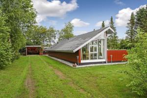una casa pequeña con techo inclinado en C11402-Skjern-Gyvelvej-74, en Skjern