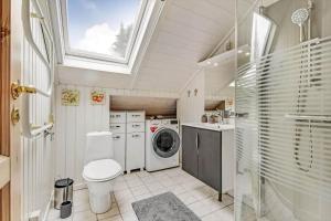 Un baño con inodoro y lavadora. en C11402-Skjern-Gyvelvej-74, en Skjern 27 fotos más