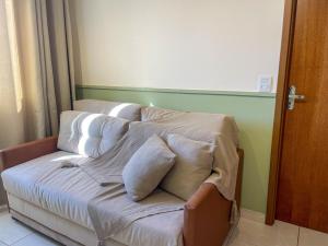 卡斯卡韦尔Apê com Ar condicionado的客房内的沙发上配有枕头