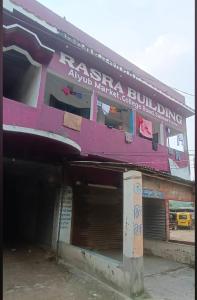 Un edificio con un edificio rosa con garaje. en Rasra building, 