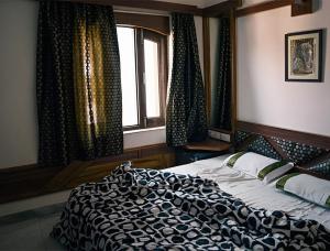 Un dormitorio con una cama y una ventana con cortinas. en Rasra building, 