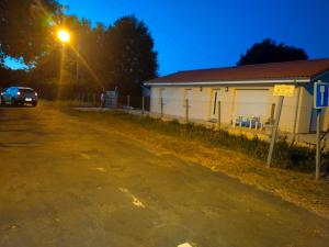 un'auto parcheggiata accanto a un edificio con un lampione di Maison neuve Hourtin , 3 chambres, proche commodités, clôturée, climatisation, terrasse a Hourtin Altre 3 foto