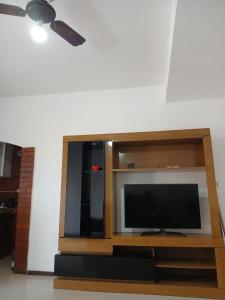 - un centre de divertissement en bois avec une télévision à écran plat dans l'établissement Temporada na Praia do Trevo - Rio das Ostras, RJ, à Rio das Ostras