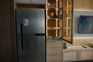 eine Küche mit einem Kühlschrank aus Edelstahl in der Unterkunft Flat Premium conforto total no centro de Porto de Galinhas, a 4mim a pé das piscinas naturais, praia ! in Porto De Galinhas