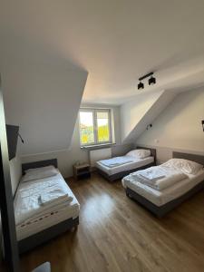 twee bedden in een kamer met twee ramen bij Garden Villa in Busko-Zdrój