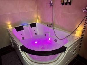 una vasca da bagno viola con luci in bagno di Skyhouse Riga Delux Penthouse & SPA a Riga Altre 6 foto
