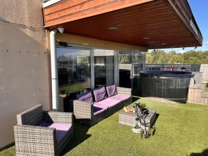 un patio coperto con mobili viola sull'erba di Skyhouse Riga Delux Penthouse & SPA a Riga