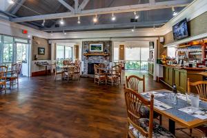 a restaurant with tables and chairs and a fireplace at Haven On The Links in Pawleys Island