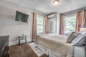 a bedroom with a bed and a flat screen tv at Chic Midtown Apartment Near Zoo, Park and Museums in Memphis