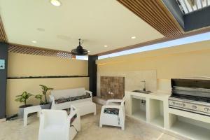 - un salon avec une cheminée et des chaises blanches dans l'établissement Elegante Casa Estrella Marina 117 Pool BBQ, à La Romana