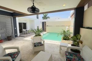 - un salon avec une piscine et des chaises dans l'établissement Elegante Casa Estrella Marina 117 Pool BBQ, à La Romana