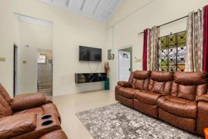 a living room with a couch and a television at Cozy Cove Villa in Drax Hall in Saint Annʼs Bay