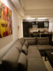 マラケシュにあるDannaMs Apartment MohamedV Hivernageのリビングルーム(大きなソファ付)、キッチンが備わります。