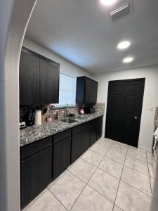 a kitchen with black cabinets and a black door at Luxury Home 3bdroom- 2bath in Donna +7 photos