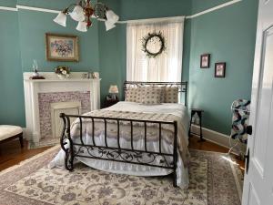 a bedroom with a bed in a room with blue walls at The Redbud Room at The Judges Chambers in Guthrie