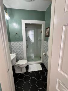 a bathroom with a toilet and a glass shower at The Redbud Room at The Judges Chambers in Guthrie