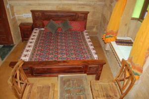 ein Schlafzimmer mit einem Holzbett in einem Zimmer in der Unterkunft Hotel Deep Mahal in Jaisalmer
