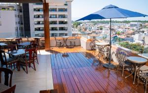 a balcony with tables and chairs and an umbrella at Vallarta Live Hotel in Puerto Vallarta