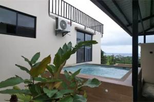 a villa with a swimming pool and a balcony at Coastal Villa Retreat with Private Jacuzzi and Garage Near Isla de la Plata in Puerto López
