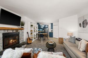 a living room with a couch and a fireplace at Fully updated condo ski in ski out hot tub pool in Lutsen