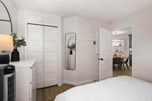 a white bedroom with a bed and a mirror at Fully updated condo ski in ski out hot tub pool in Lutsen +23 photos