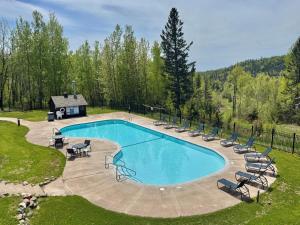 a swimming pool with chairs and a house at Fully updated condo ski in ski out hot tub pool in Lutsen