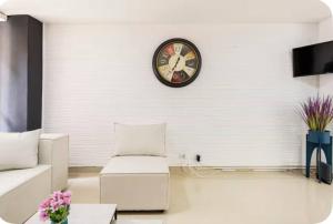 a living room with a clock on the wall at Group Stay in Poblado - Walk Everywhere - King Bed in Medellín +52 photos