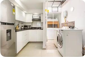 a white kitchen with a washing machine in it at Group Stay in Poblado - Walk Everywhere - King Bed in Medellín