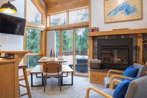 Una sala de estar con chimenea y una mesa y sillas. en Resort Hot Tub Pool Gym Ski-in out Fire Pits, en Lutsen