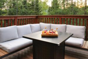 Un sofá en una terraza con un bol de fruta en una mesa. en Resort Hot Tub Pool Gym Ski-in out Fire Pits, en Lutsen