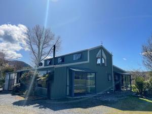 a green house with windows on the side of it at Glacier Barn House in Tatare