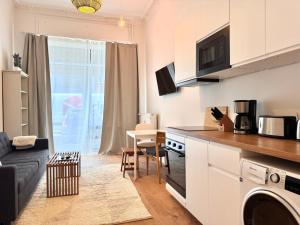 a kitchen and living room with a couch and a table at Best Spot in XBerg in Berlin