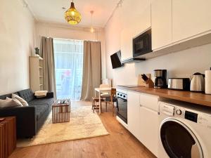 a kitchen and living room with a couch and a table at Best Spot in XBerg in Berlin