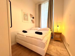 a bedroom with a bed with white sheets and a window at Best Spot in XBerg in Berlin