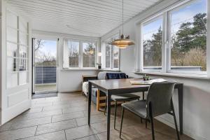 a dining room with a table and chairs and windows at C11629-Hemmet-Ildervej-10 in Hemmet