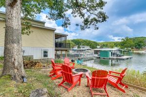レイク・オザークにあるCentral Waterfront Home with Dock in Lake Ozark!の湖のそばのテーブルの周りに赤い椅子が並んでいる