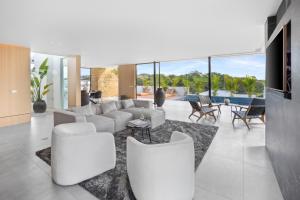 a living room with a white couch and chairs at Villa Juba Tamarindo Centro in Tamarindo