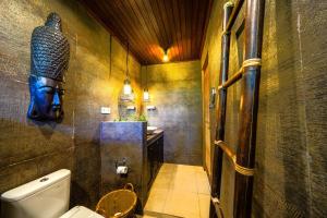 a bathroom with a toilet and a statue on the wall at Villa ABBI Luxury 2 Bedroom Villa - Legian Seminyak in Seminyak +5 photos