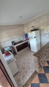 a kitchen with a white refrigerator and a sink at Suíte319 in São José dos Campos