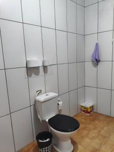 a white bathroom with a toilet with a black lid at CASA Aconchegante MASSUDA in São Paulo +12 photos
