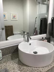 ein Badezimmer mit einem weißen Waschbecken und einer Badewanne in der Unterkunft Amani Grand Resort Residences in Mactan Cebu International