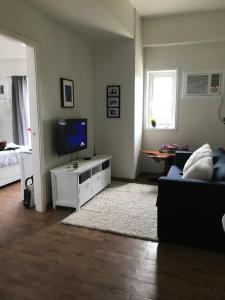 ein Wohnzimmer mit Fernseher und Sofa in der Unterkunft Amani Grand Resort Residences in Mactan Cebu International + 5 Fotos